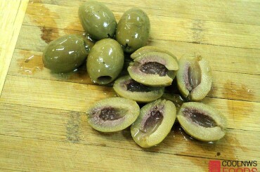 Гигантские оливки режем пополам.