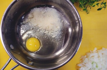 Подготовим в сотейнике с толстым дном соус для пасты: разобьем 1 яйцо и добавим пармезан со свежемолотым перцем, перемешаем деревянной лопаткой.