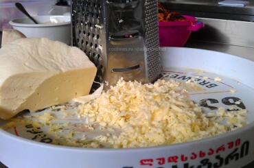 Подготавливаем сыр сулугуни - натираем его на терке .