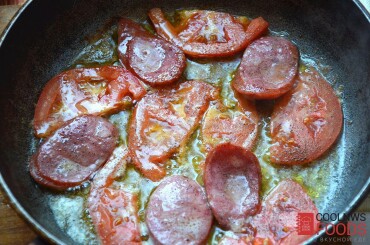 Обжариваем на сливочном масле кусочки краковской колбасы с помидорами. Солим, но немного.