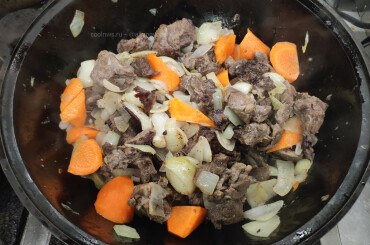 Далее добавляем крупно нарезанную морковь и также обжариваем вместе с мясом и луком.