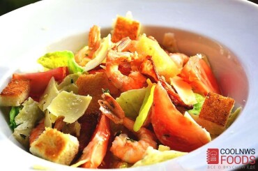 Уложить заправленные соусом цезарь листья салата в миску. сверху положить креветки, нарезанные четвертинами томаты черри. Ломтики бекона и крутоны. Посыпать салат тертым пармезаном.