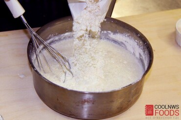 Затем постепенно, чтобы не было комков, добавляем пшеничную муку и мешаем венчиком, пока тесто не достигнет консистенцией жидкой сметаны. Готовое тесто накрыть полотенцем и убрать в теплое место на 40 минут.