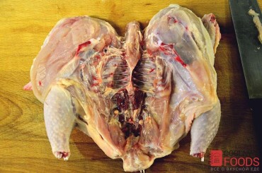 Тушку цыпленка промыть, обсушить, удалить если есть оставшиеся перья и разрезать вдоль со стороны грудок. Развернуть цыпленка как книгу.