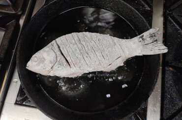Обваливаем рыбу в муке и жарим карпа на расскаленной сковороде (сначала на сильном огне) 2-3 минуты с каждой стороны, 