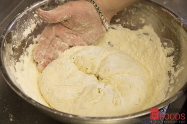Затем небольшими порциями добавляем остальную муку и вымешиваем тесто до тех пор, пока тесто не будет отставать от рук.